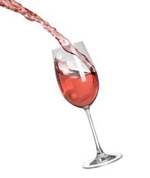 Pouring delicious rose wine into glass on white background