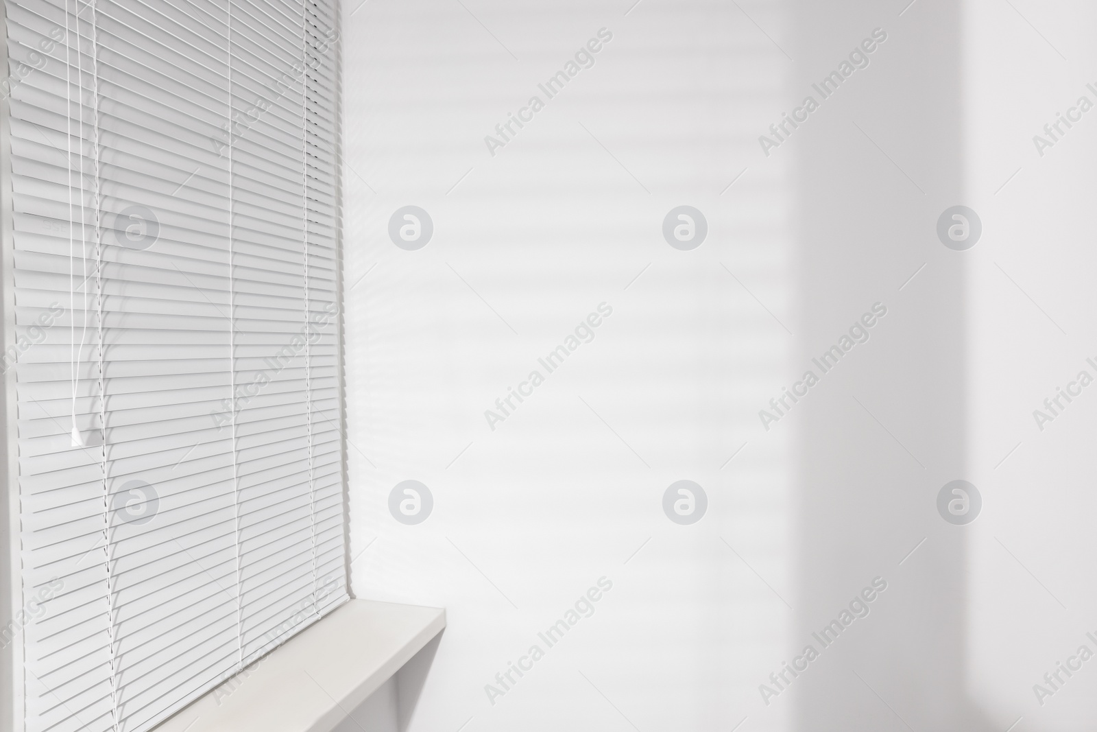 Photo of Stylish window with horizontal blinds in room