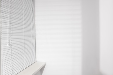 Photo of Stylish window with horizontal blinds in room
