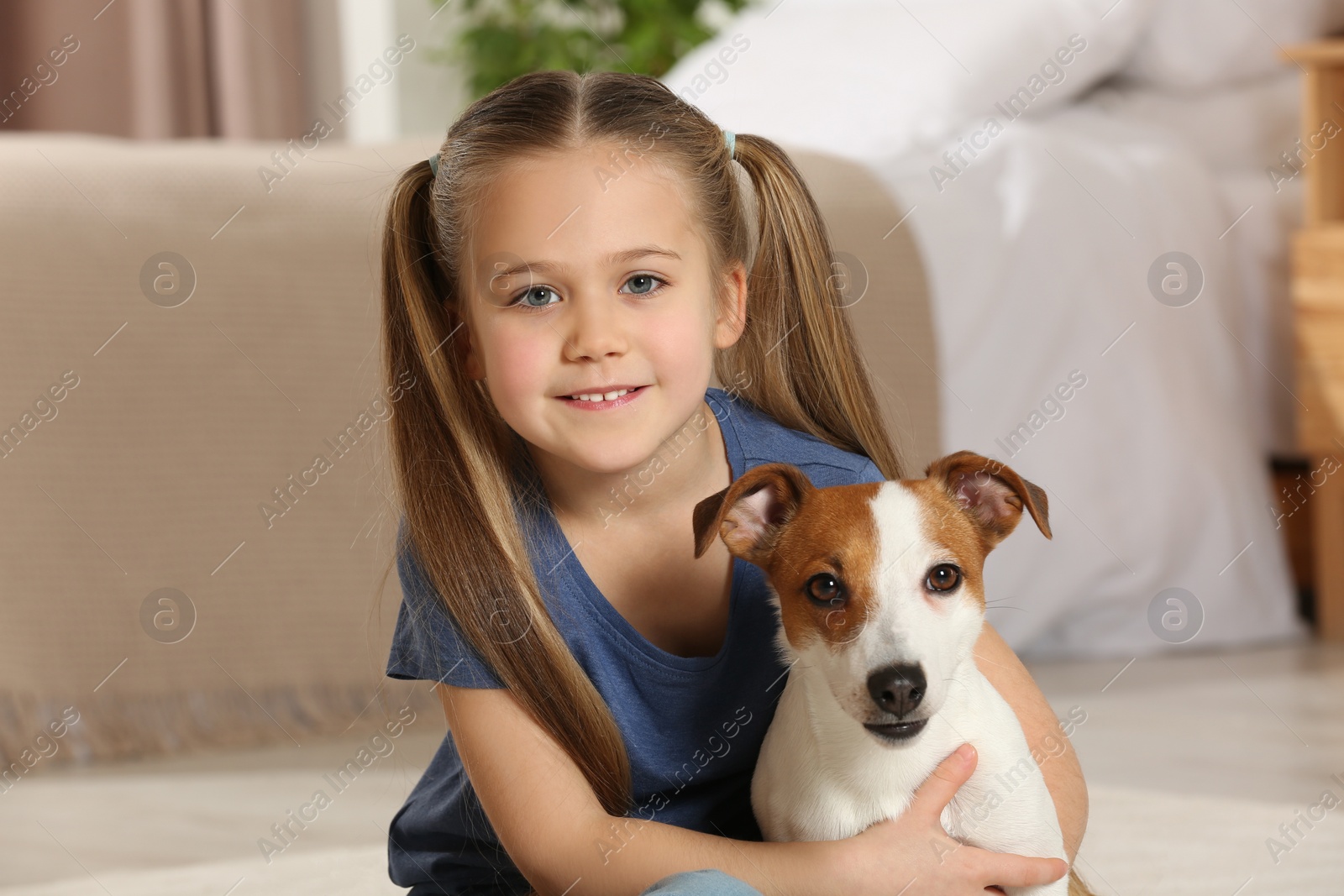 Photo of Cute girl with her dog at home. Adorable pet