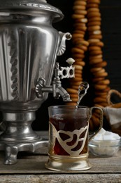 Photo of Delicious tea and ring shaped Sushki (dry bagels), focus on cup with samovar. Space for text