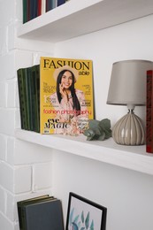 Photo of Fashion magazine on white shelf in room