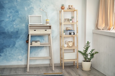 High wooden table with laptop as stand up workplace in modern interior