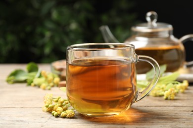 Cup of tea and linden blossom on wooden table