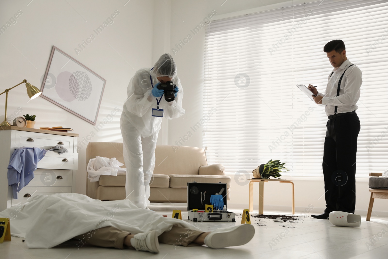 Photo of Investigators working at crime scene with dead body