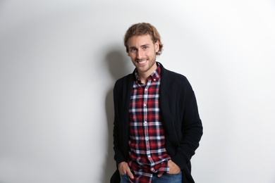 Photo of Handsome young man in shirt and warm sweater on white background