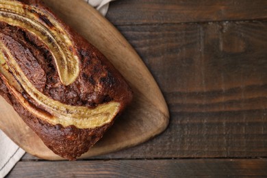 Photo of Delicious banana bread on wooden table, top view. Space for text