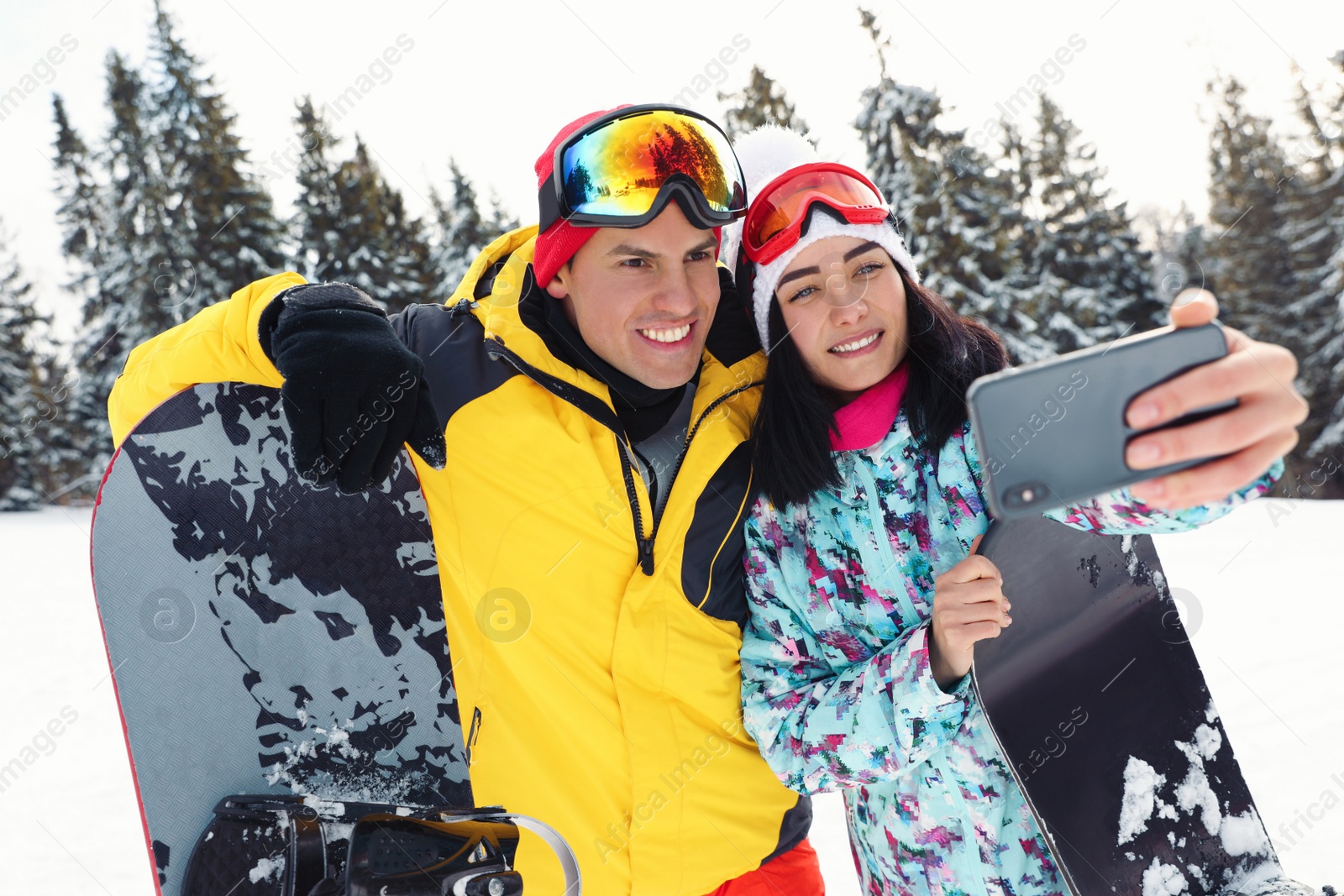 Photo of Couple taking selfie on snowy hill. Winter vacation