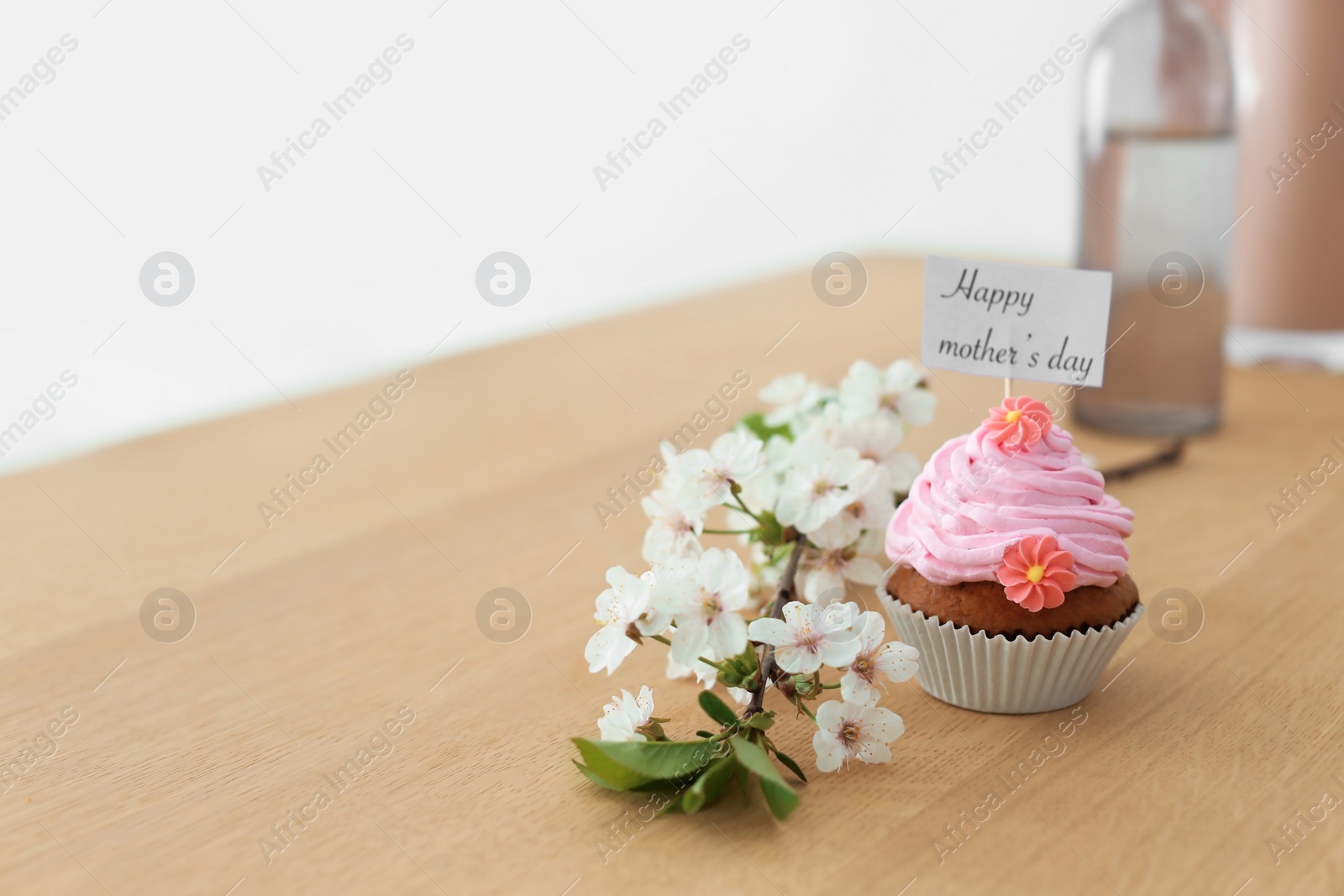 Photo of Tasty cupcake and flowers for Mother's Day on table