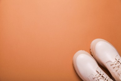 Photo of Pair of stylish leather shoes on light brown background, flat lay. Space for text