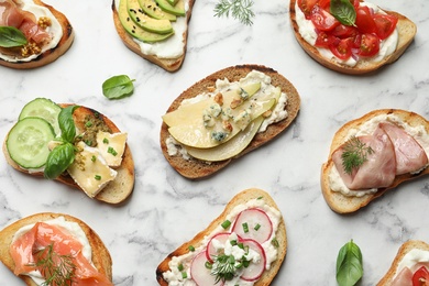 Photo of Different tasty bruschettas on marble background, flat lay