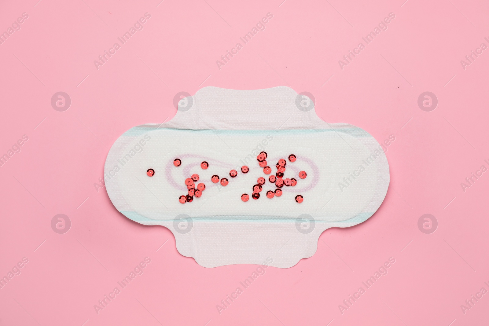 Photo of Menstrual pad with red sequins on pink background, top view