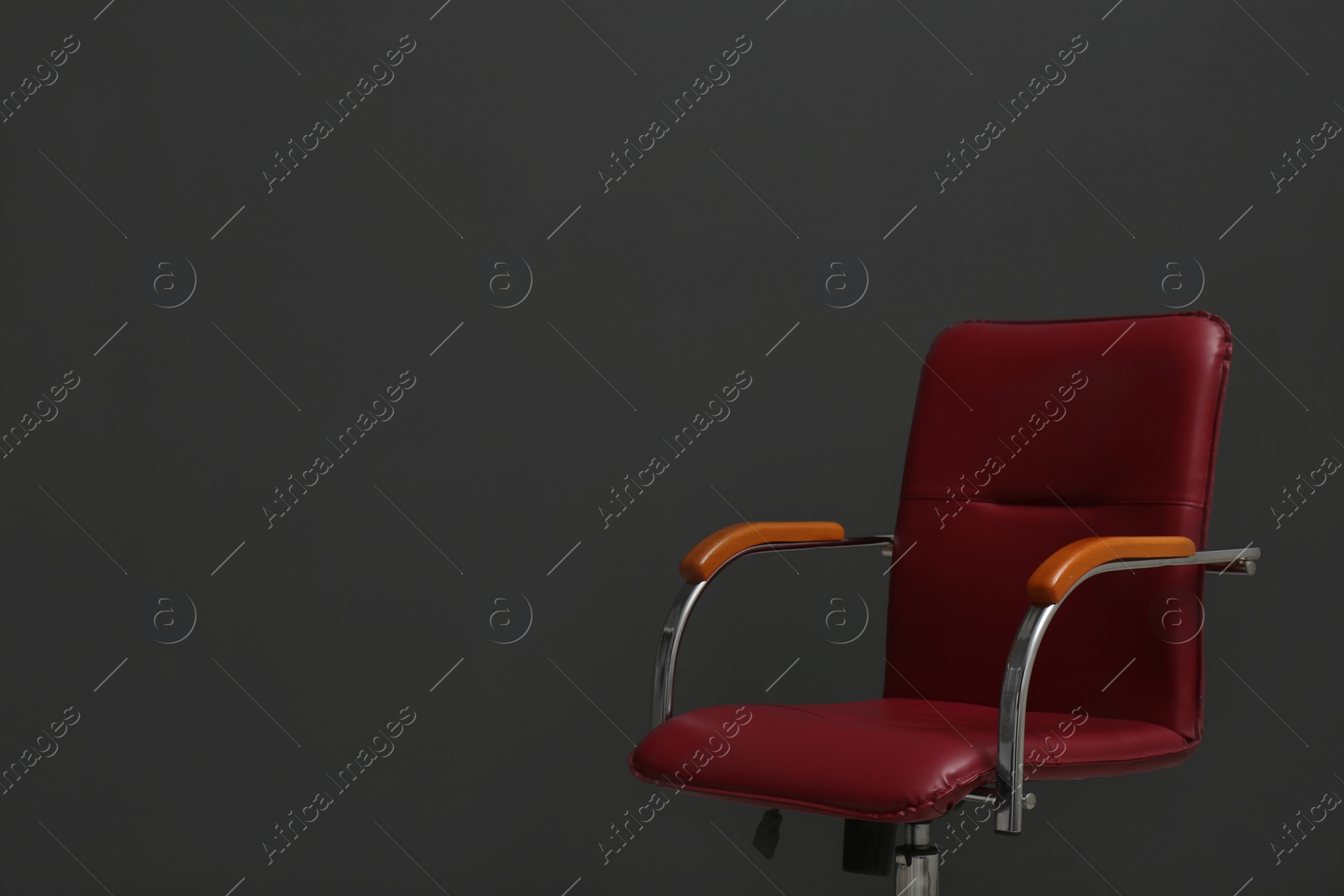 Photo of Comfortable office chair on black background. Space for text