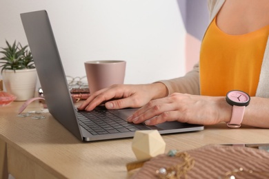 Photo of Woman using laptop at desk, closeup. Beauty blogger