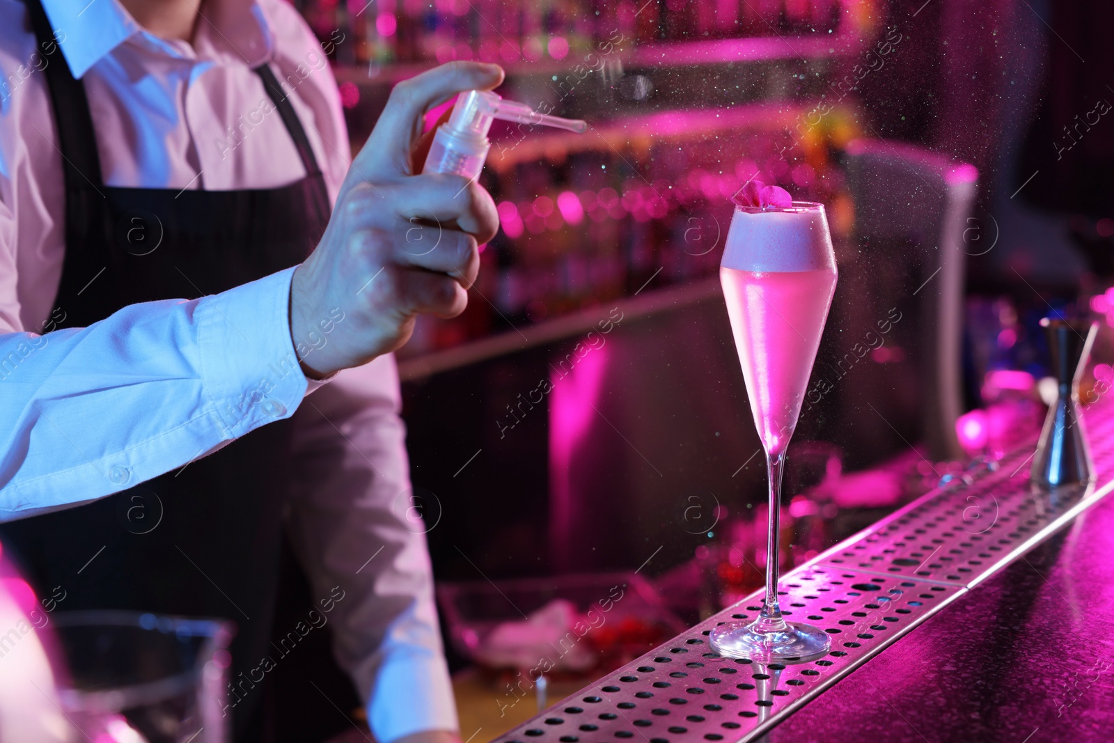 Photo of Bartender making fresh alcoholic cocktail at counter in bar, closeup