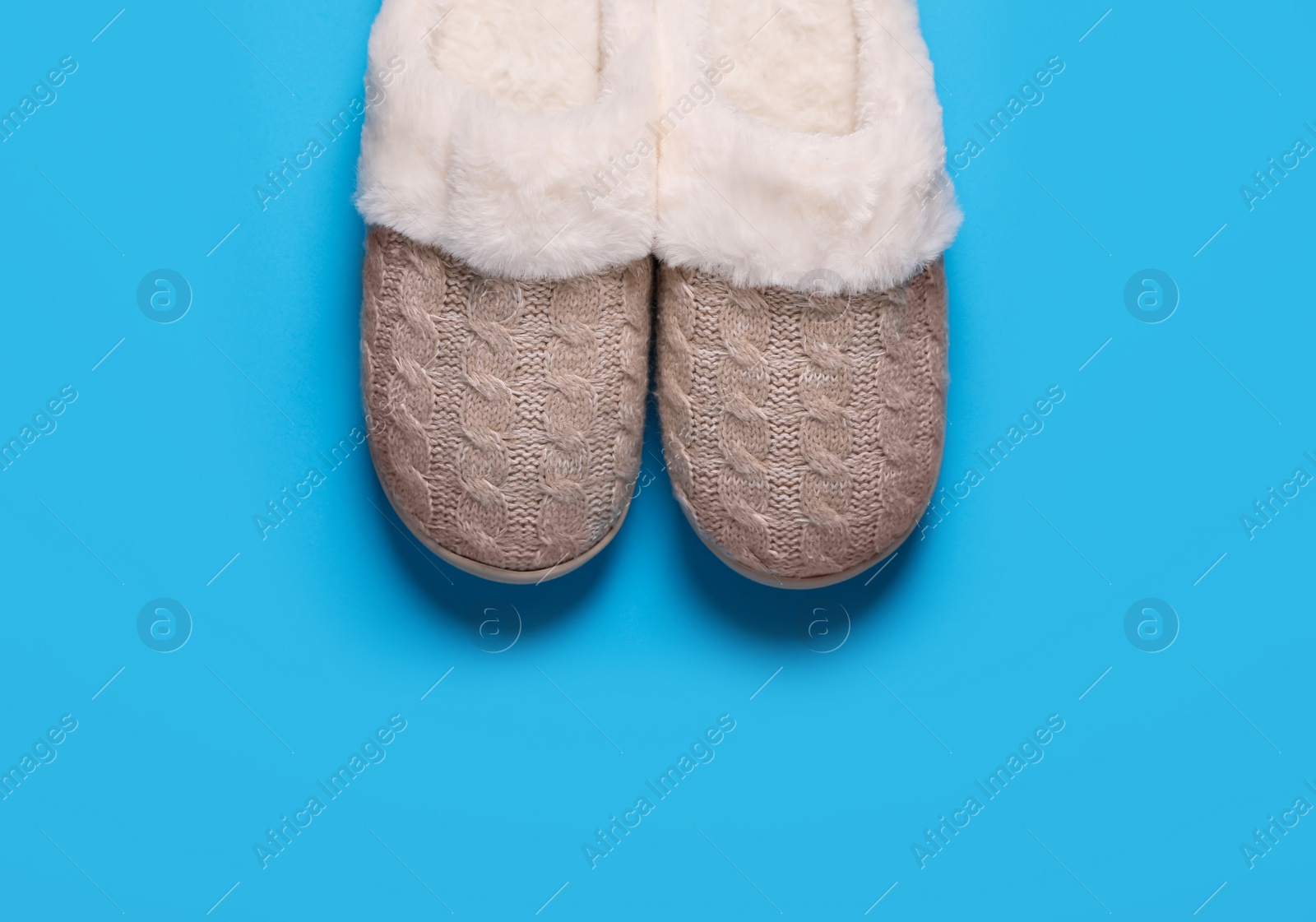 Photo of Pair of beautiful soft slippers on light blue background, top view. Space for text