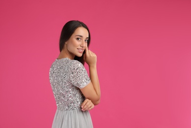 Young woman wearing stylish dress on pink background. Space for text