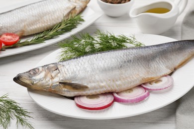 Photo of Delicious salted herrings and ingredients on white wooden table