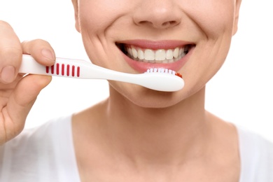 Photo of Young woman brushing her teeth on white background, closeup