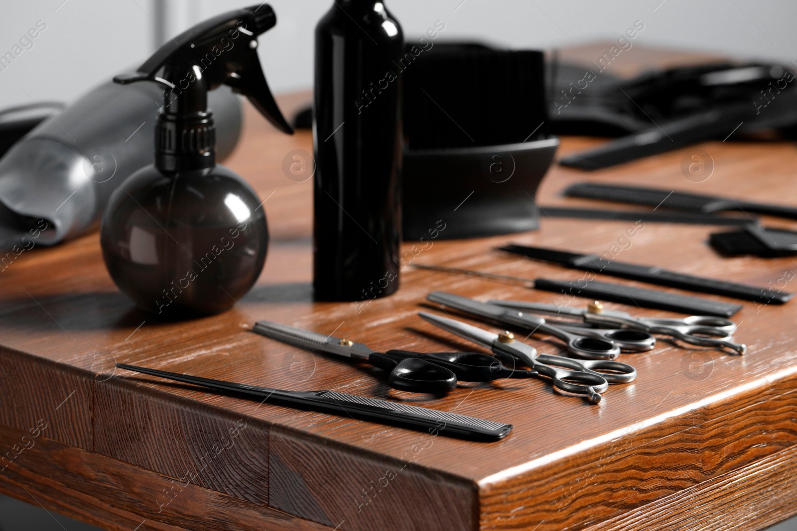 Photo of Hairdresser tools. Different scissors and combs on wooden table, closeup