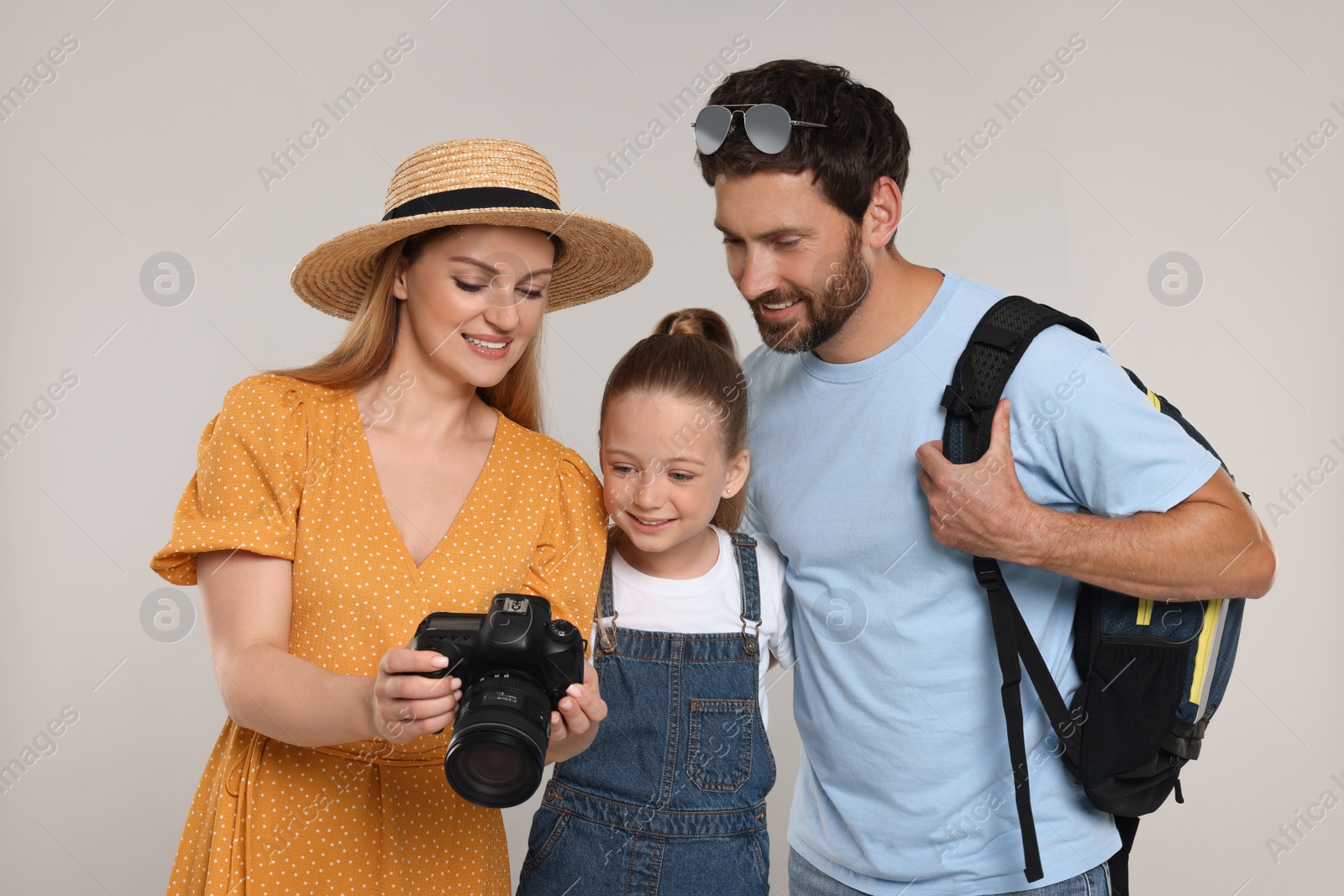 Photo of Happy family looking into camera on light grey background