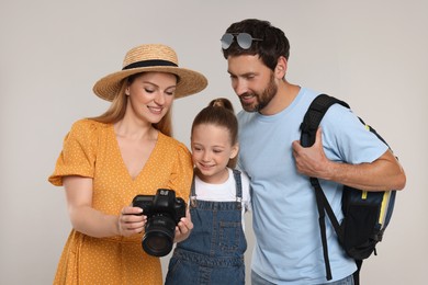 Happy family looking into camera on light grey background