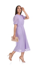 Young woman wearing stylish lilac dress with elegant clutch on white background
