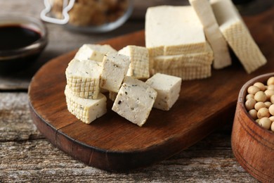 Photo of Natural tofu on wooden table, closeup. Soy product