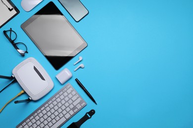Photo of Flat lay composition with modern Wi-Fi router on light blue background, space for text