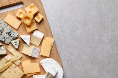 Photo of Cheese plate on light grey table, top view. Space for text