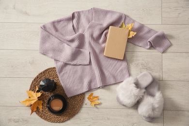 Photo of Flat lay composition with cozy knitted sweater on wooden floor