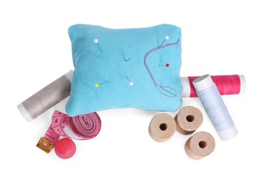 Photo of Pincushion, pins and other sewing tools isolated on white, top view