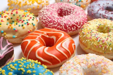 Photo of Delicious glazed donuts on white background, closeup