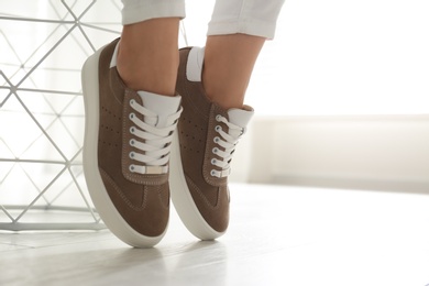 Photo of Woman wearing comfortable stylish shoes indoors, closeup