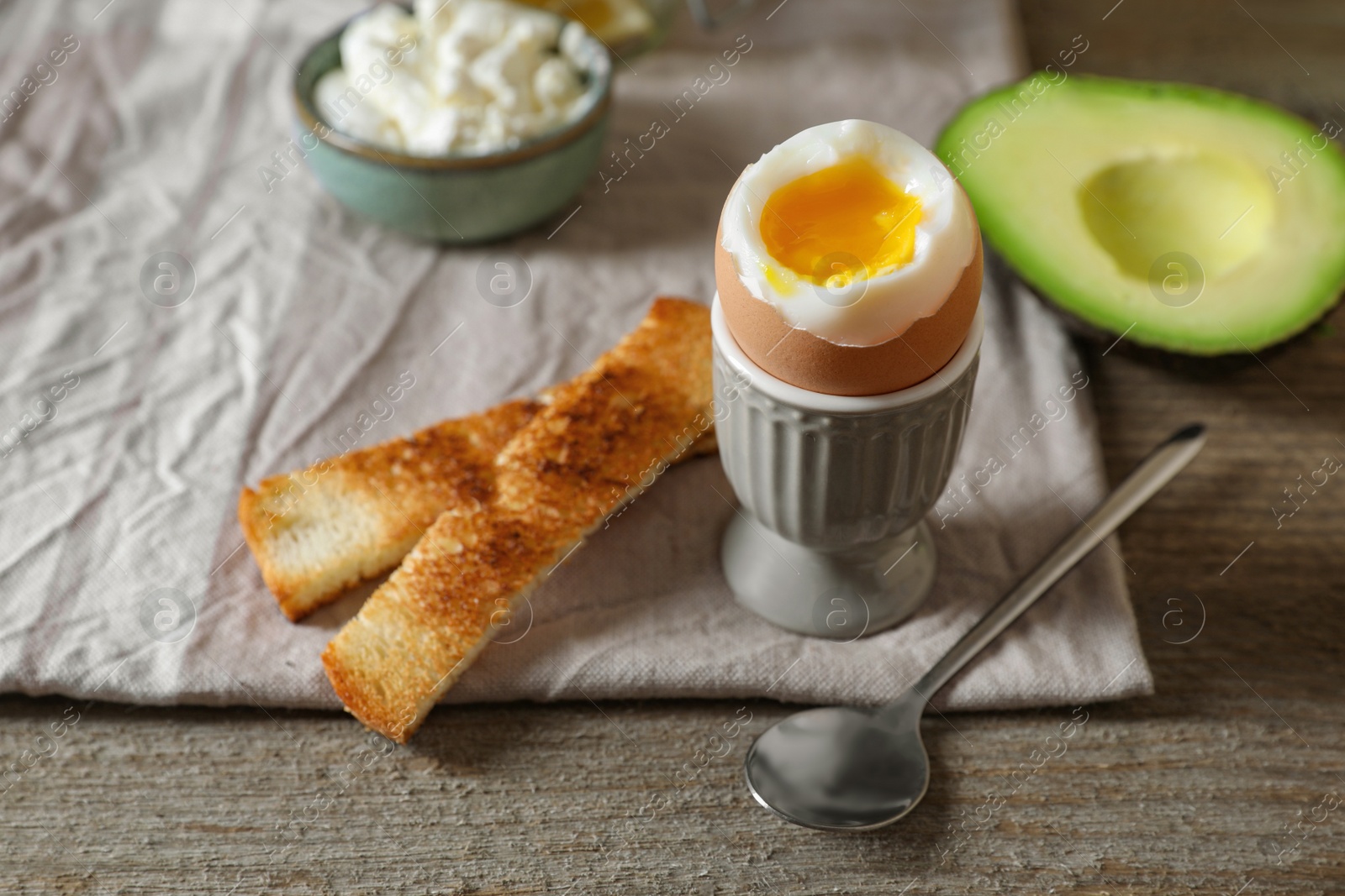 Photo of Soft boiled egg served for breakfast on wooden table