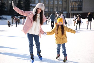 Image of Mother and daughter spending time together at outdoor ice skating rink