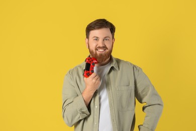 Photo of Smiling man with game controller on pale yellow background