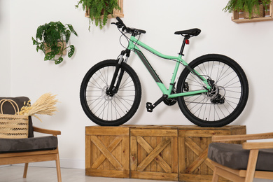 Photo of Modern bicycle and comfortable armchairs in stylish living room interior