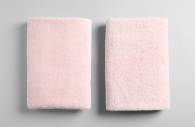 Photo of Soft folded towels on light background, top view