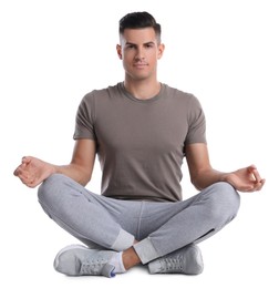 Photo of Handsome man meditating on white background. Harmony and zen