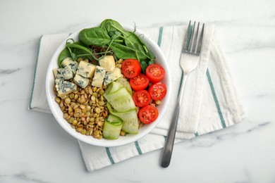 Photo of Delicious lentil bowl with blue cheese, tomatoes and cucumber on white marble table, top view