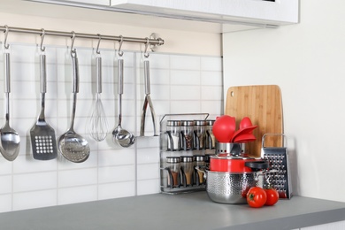Photo of Set of clean cookware and utensils on table in modern kitchen