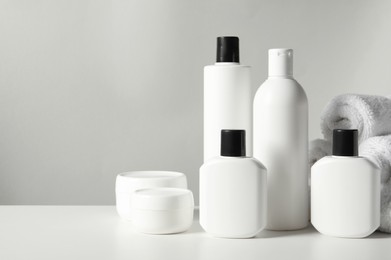 Photo of Different bath accessories on white table against grey background, closeup. Space for text