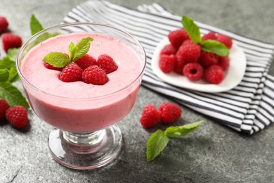 Photo of Delicious raspberry mousse with mint on grey table, space for text