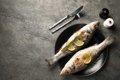 Photo of Delicious baked fish served on grey table, top view. Space for text