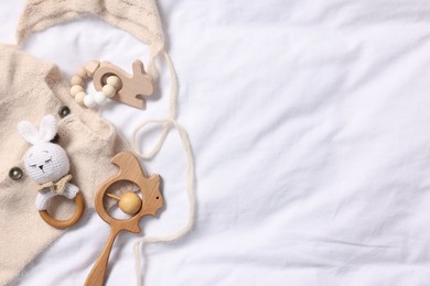 Photo of Different baby accessories on white fabric, top view. Space for text