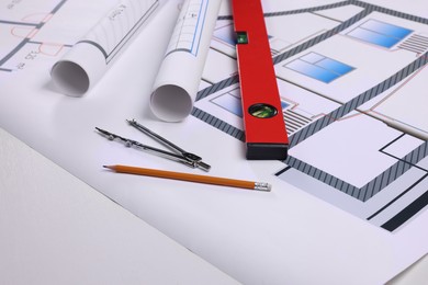 Photo of Construction drawings, pair of compasses, pencil and bubble level on white background