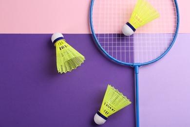 Photo of Badminton racket and shuttlecocks on color background, flat lay. Space for text