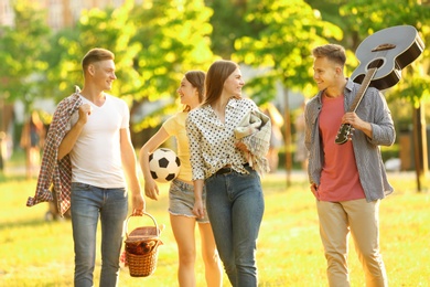 Photo of Young people with picnic basket in park on summer day
