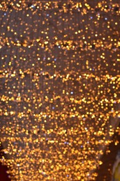 Photo of Blurred view of beautiful lights hanging from ceiling indoors. Bokeh effect